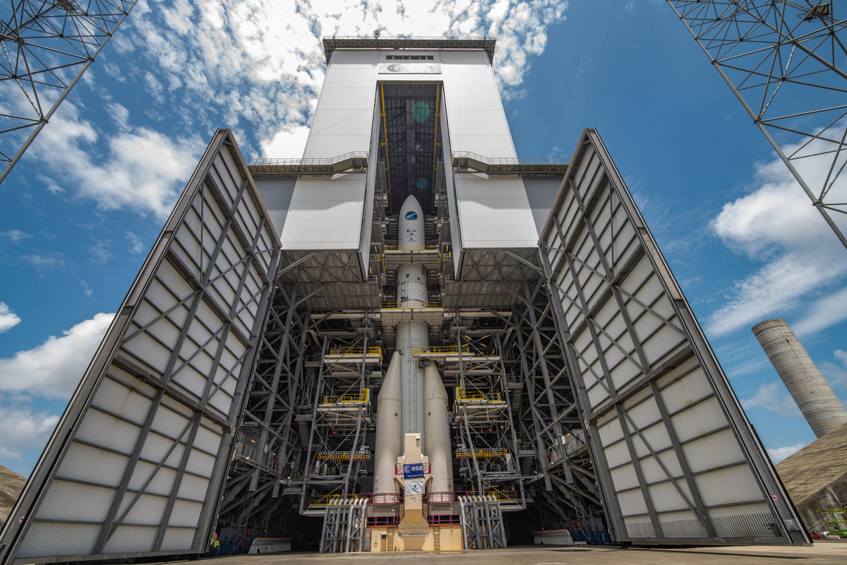 A photo of the fully assembled Ariane 6 spacecraft revealed behind open hangar doors.