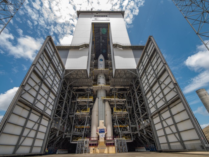 A photo of the fully assembled Ariane 6 spacecraft revealed behind open hangar doors.