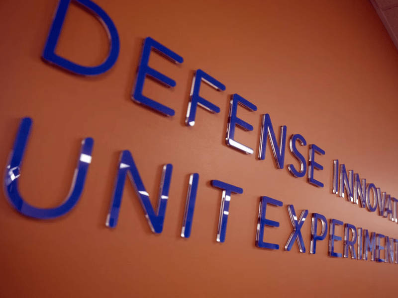 Lettering reading "Defense Innovation Unit Experimental" on an office wall.